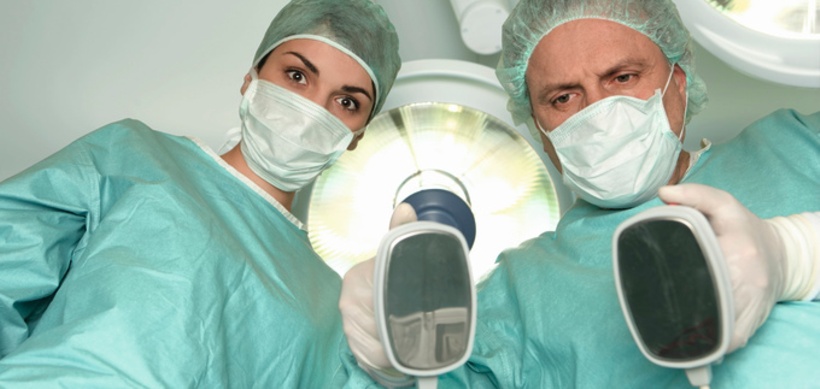 Operationsarzt mit Mundschutz neben einer Krankenschwester