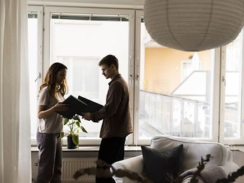 Paar hält Ordner neben dem Fenster