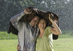 Paar steht unter Jacke im Regen