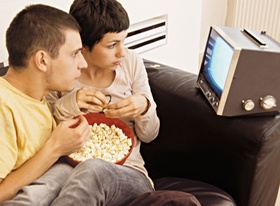 Paar zuhause, mit Popcorn beim Fernsehen