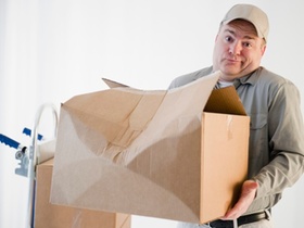 Paketbote mit zerdrücktem Paket