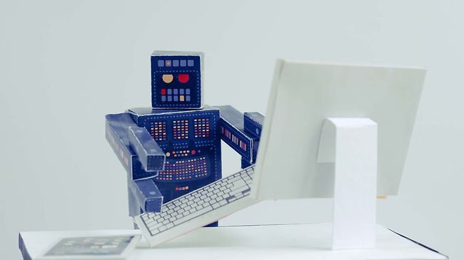 Papierroboter am Schreibtisch
