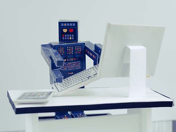 Papierroboter am Schreibtisch