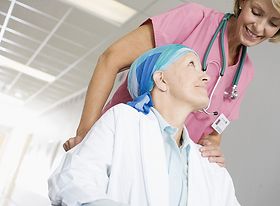 Pflegekraft oder Ärztin mit Patientin im Rollstuhl