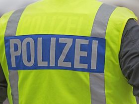 Polizeibeamter mit Warnweste, Aufschrift Polizei, Rückenansicht