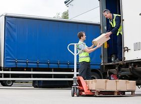 Postbote übergibt Pakete aus LKW