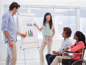 Attractive business team presenting graphs and their work to fellow employees