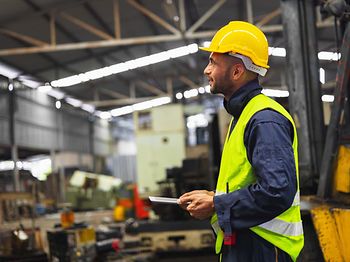 Produktion_Mann mit iPad in Produktionshalle
