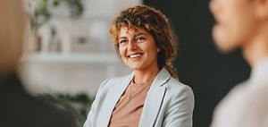 Confident businesswoman smiling while interacting with colleagues