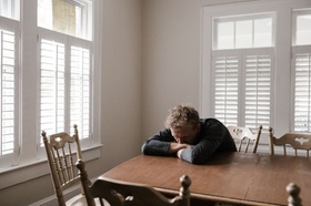 Psychische Belastung: Mann legt Kopf auf dem Tisch