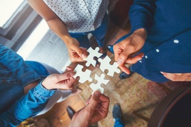 Group of business people holding a jigsaw puzzle pieces. Jigsaw pieces fit into each other. Business