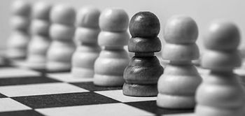 Rassismus: Viele weiße Schachfiguren und eine schwarze