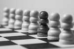 Rassismus: Viele weiße Schachfiguren und eine schwarze