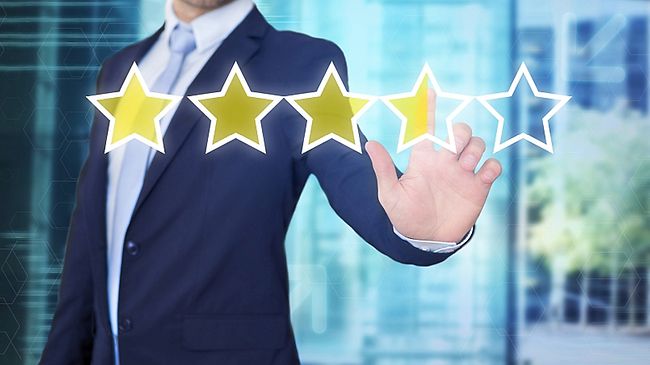 Rating, Bewertung - Mann im Anzug drückt auf Sternchen