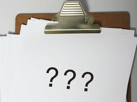 Reißbrett mit drei Fragezeichen