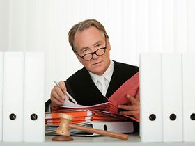 Richter liest am Schreibtisch Akten