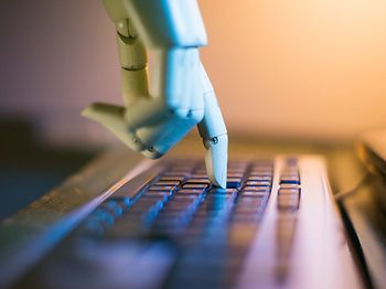 Roboterhand tippt auf Tastatur