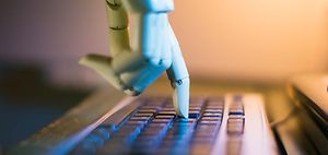 Roboterhand tippt auf Tastatur
