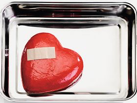 Rotes Herz mit Pflaster liegt in Metallschale