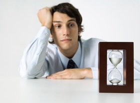 Sanduhr vor wartendem Mann