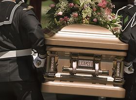 Sarg der von Leuten in Uniform getragen wird