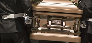 Sarg der von Leuten in Uniform getragen wird