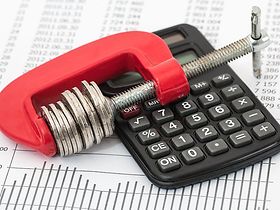 Schraubwinge mit Münzen auf Bilanz