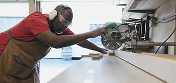 Schreiner Handwerker afrikanischer Abstammung sägt etwas zu