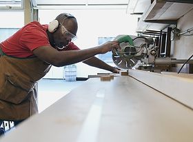 Schreiner Handwerker afrikanischer Abstammung sägt etwas zu
