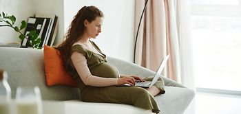 Schwangere Frau am Laptop