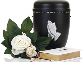 Schwarze Urne mit Rose und Bibel