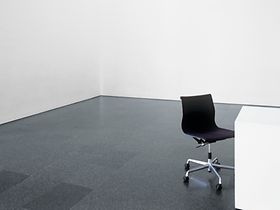 Schwarzer Stuhl an Tisch in leerem Raum