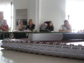 Seminar Unterlagen im Vordergrund Menschen im Hintergrund