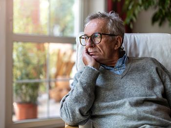 Senior schaut aus dem Fenster