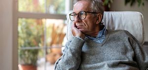 Senior schaut aus dem Fenster