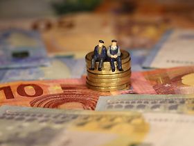 Senioren sitzen auf Geldmünzen