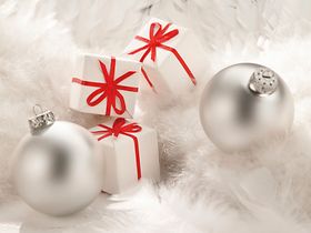 Silberne Christbaumkugeln, weisse Paeckchen mit roten Schleifen, 