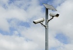 A solar powered surveillance camera on a pole.