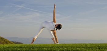 sportliche Frau auf Feld in Yoga Position