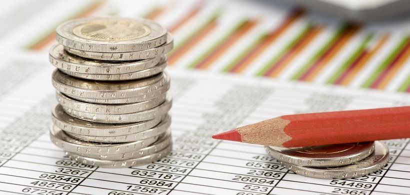Stapel von Euromünzen auf Finanztabellen