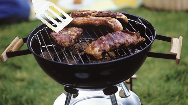 Steaks und Bratwuerste auf Grill, Leute im Hgr.