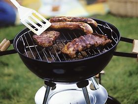 Steaks und Bratwuerste auf Grill, Leute im Hgr.