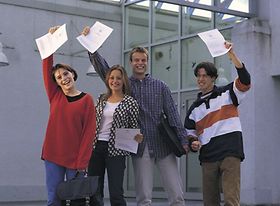 Studenten halten ihre Zeugnisse in die Höhe