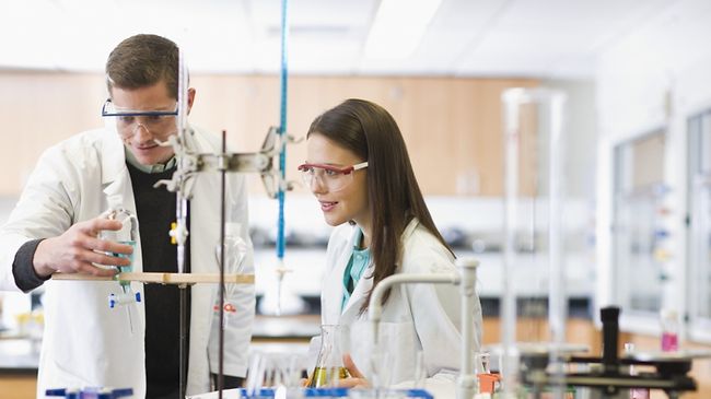 Studenten im Labor mit Schutzkittel und Schutzbrille