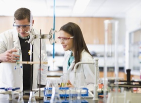 Studenten im Labor mit Schutzkittel und Schutzbrille