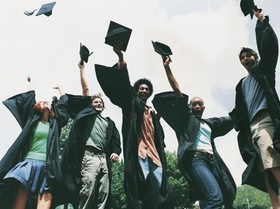 Studenten werfen Doktorhüte in die Luft
