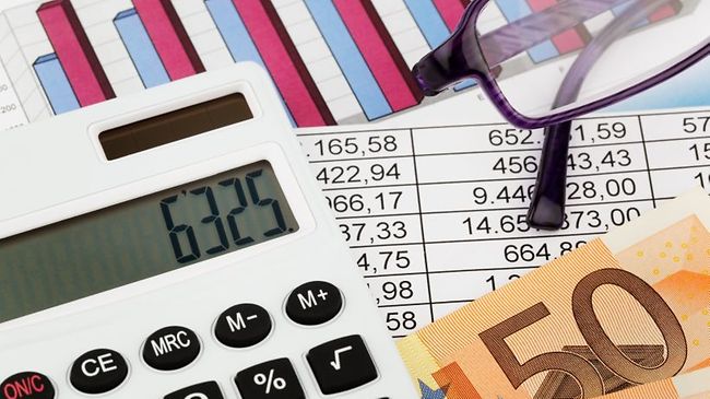 Taschenrechner vor Bilanzen, Geld und Lesebrille