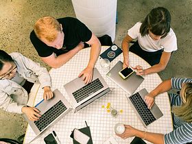 Team arbeitet an Laptops