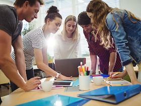 Team arbeitet zusammen an Laptop