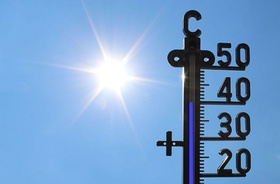 Thermometer zeigt 40 Grad vor blauem Himmel mit Sonne